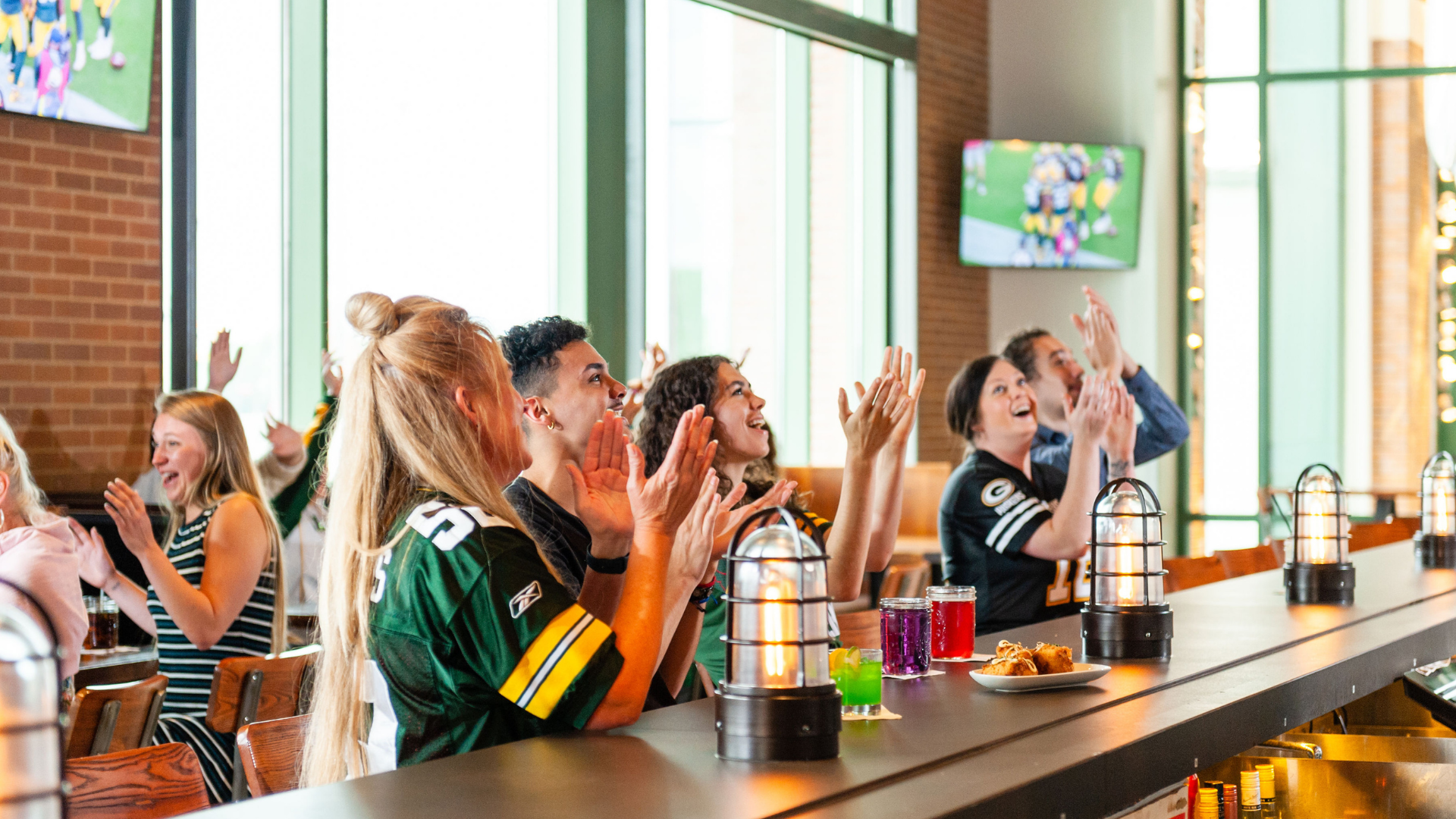 Packers fans cheering at the bar.