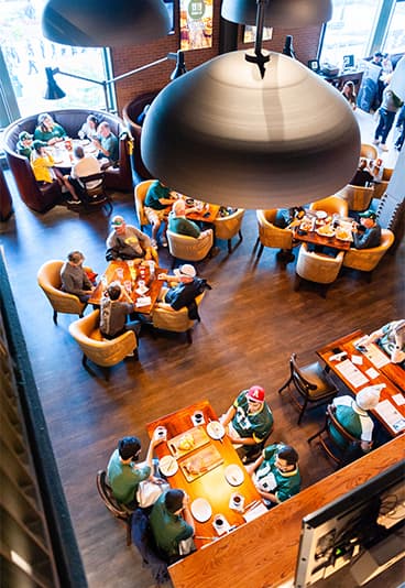 various people sitting at tables in a restaurant wearing football jerseys